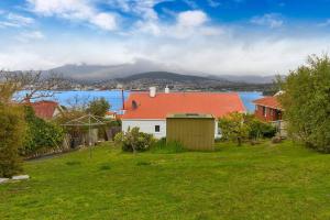BelleriveBellerive Bluff magic - renovated home with views的绿色庭院中一座红色屋顶的房子