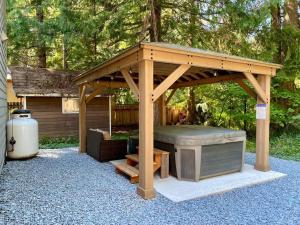 阿什福德NEW Modern Cabin! 5mi to Mt Rainier National Park! Hot Tub & Wifi的后院的木制凉亭设有热水浴池