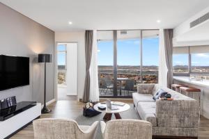 悉尼帕拉马塔教堂街美利通公寓式酒店的带沙发和电视的客厅