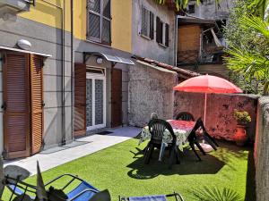 韦尔巴尼亚Residenza Silvana Apt Cielo and Apt Giardino on the ground floor with parking的一个带桌子和遮阳伞的庭院