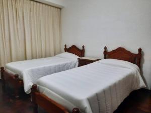 科尔多瓦Hermoso Departamento centrico的两张睡床彼此相邻,位于一个房间里