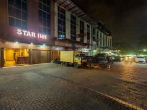 棉兰Star Inn Medan的一辆夜间停在大楼前的卡车