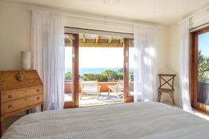 欧尼坦基赛普拉斯岭村别墅的一间卧室配有一张床,享有海景