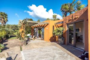 欧尼坦基赛普拉斯岭村别墅的一座带庭院和棕榈树的橙色房子