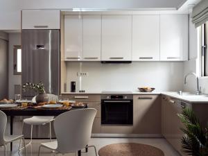 阿克罗蒂Stelle Mare Villa的厨房配有白色橱柜和桌椅