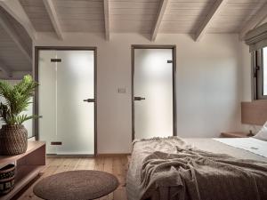 阿克罗蒂Stelle Mare Villa的一间卧室设有两扇玻璃门和一张床