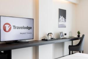 普吉镇Travelodge Phuket Town的平面电视坐在房间内的桌子上