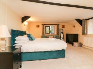 克雷迪顿The Thatched Cottage的一间卧室设有一张大床和一个窗户。