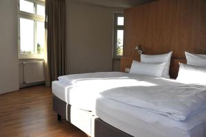 伍珀塔尔Gästehaus Auf dem Heiligen Berg B&B的卧室配有一张带白色床单和枕头的大床。