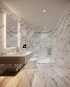 曼谷Leon Lasalle Hotel and Residences的白色的浴室设有水槽和镜子