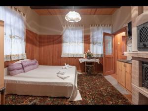 尤尔马拉Valensija - Cute cottage in big yard的一间卧室配有一张床和一个壁炉