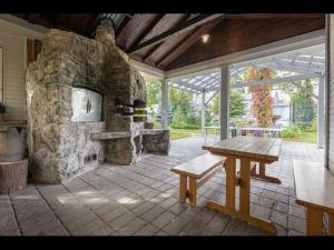 尤尔马拉Valensija - Cute cottage in big yard的庭院设有石制壁炉和木桌。