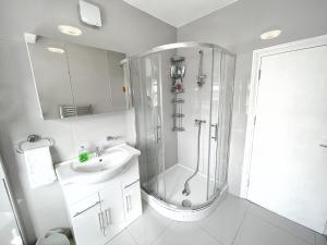 伦敦Luxurious House near Excel- Air Conditioning, 9 Beds, 2 Baths, Garden, fast WiFi的带淋浴和盥洗盆的白色浴室