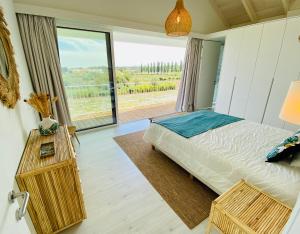 孔波尔塔Villa Possanco, Comporta beach villa的一间卧室设有一张床和一个大窗户