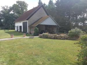 VeikvitzRuegen_Fewo 155的一座带草地庭院的白色小房子