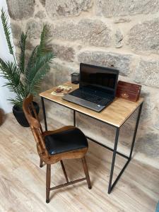 奥伦塞Casa Anduriña的一张桌子上的笔记本电脑和椅子