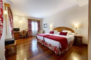 佩纳菲尔AZZ Peñafiel Las Claras Hotel & Spa的酒店客房设有一张大床和一张书桌。