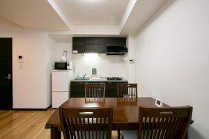 东京Minn Machiya的厨房配有桌椅和冰箱。