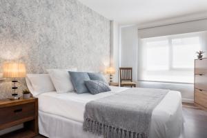 安度亚尔Viviendas con Fines Turísticos "Quivir Pidal"的一间卧室配有带白色床单和蓝色枕头的床。