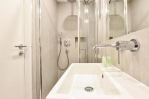 伦敦Earls Court East Serviced Apartments by StayPrime的白色的浴室设有水槽和淋浴。