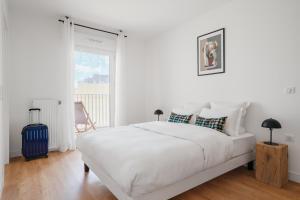 默东Edgar Suites - Meudon-la-Forêt的白色的卧室设有一张白色大床和一个窗户。