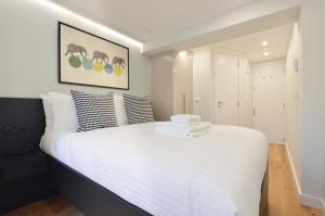 伦敦Earls Court East Serviced Apartments by StayPrime的一间卧室配有带白色床单和枕头的床。