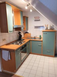 圣温德尔Ferienwohnung Villa Wolke的厨房配有蓝色橱柜和炉灶烤箱。