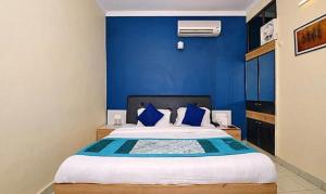 德拉敦FabExpress Central Park的蓝色卧室,配有蓝色墙壁的床