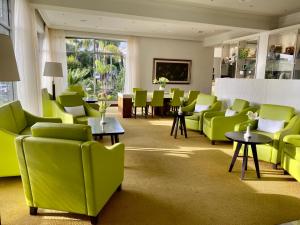 拉克鲁斯Hotel Tigaiga的一间设有绿色椅子和桌子的等候室