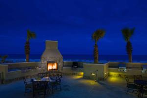 奥兰治比奇Escapes! To The Shores Orange Beach, A Ramada by Wyndham的棕榈树和海洋庭院内的壁炉