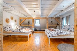 小莫拉夫卡Chalupa U Potoka的客厅设有三张床,铺有木地板。