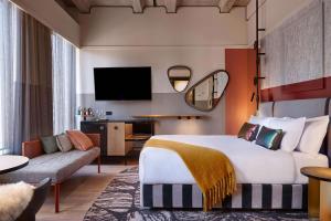 奥克兰QT Auckland的酒店客房设有一张大床和一张沙发。