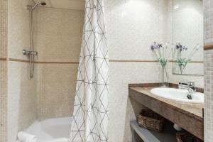 巴塞罗那Lodging Apartments Liceu 11的带浴缸和盥洗盆的浴室