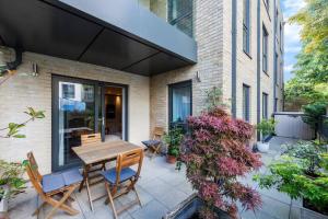 伦敦STYLISH 2 BED 2 BATH IN HIGHGATE & FREE PARKING的庭院配有木桌和椅子