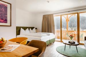 圣沃尔夫冈Seehotel Berau的酒店客房配有一张床铺和一张桌子。