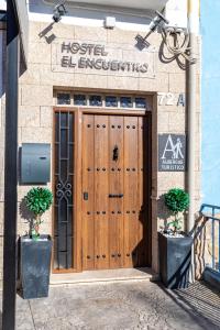 贝拉新镇Albergue El Encuentro的建筑上的木门,上面有标志