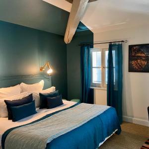 索尔格河畔利勒索格酒店-法国之心的一间卧室配有一张蓝色墙壁的床和一扇窗户