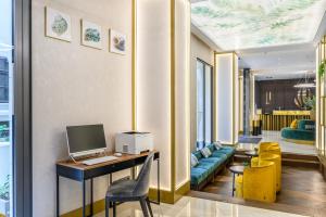 布达佩斯Emerald Hotel的客房设有一张桌子、一台电脑和黄色椅子