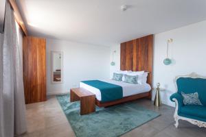Santa BárbaraCasa dos Romeiros的一间卧室配有一张床和一张蓝色椅子
