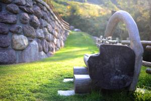 Roncobello奥洛比阿尔卑斯度假酒店的石墙旁的水壶雕像