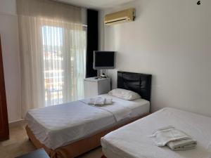 切什梅Blue otel çeşme的酒店客房设有两张床和电视。