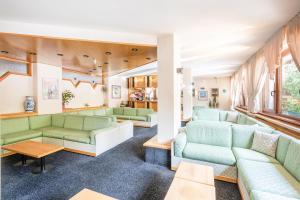 摩德纳迪-坎皮格里奥阿尔皮纳酒店的客厅配有绿色的沙发和桌子