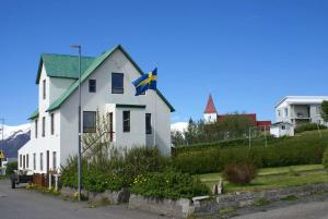 HríseyÁsgarður的前面有旗帜的白色房子
