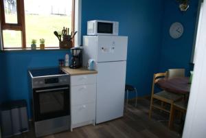 HríseyÁsgarður的厨房配有白色冰箱和微波炉