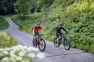 AusserbrazBurtscherhof in Braz的两个人骑着自行车在土路上