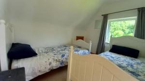 拉斯姆兰Idyllic 3-Bed House minutes from village & beach的一间卧室设有两张床和窗户。