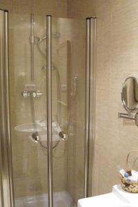 洛尔基TCH酒店的浴室里设有玻璃门淋浴