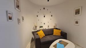 布拉格Apartment near Congress Centre I.的客厅配有沙发和墙上的时钟