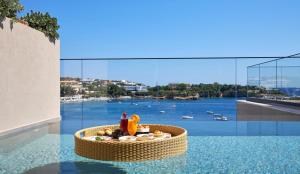 阿齐亚佩拉加Castello Infinity Suites - Adults Only的一个带餐桌的游泳池,享有水景