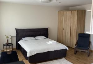 帕内韦日斯S&A apartamentai的一间卧室配有一张大床和一张蓝色椅子